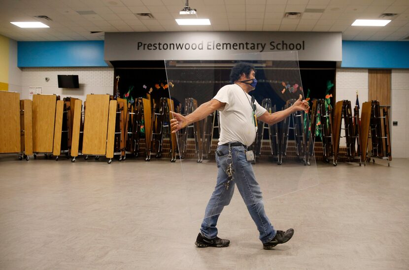 Daniel Limon, a Richardson ISD maintenance worker, carried a germ barrier to be installed in...