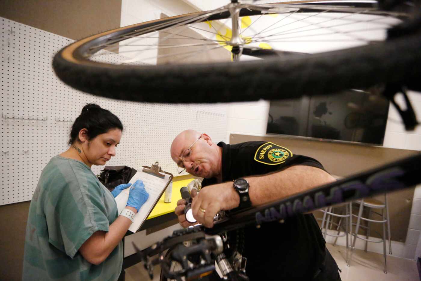 Detention Services Officer Roy Love teaches Eliza Zabaleta about bicycle maintenance at Lew...