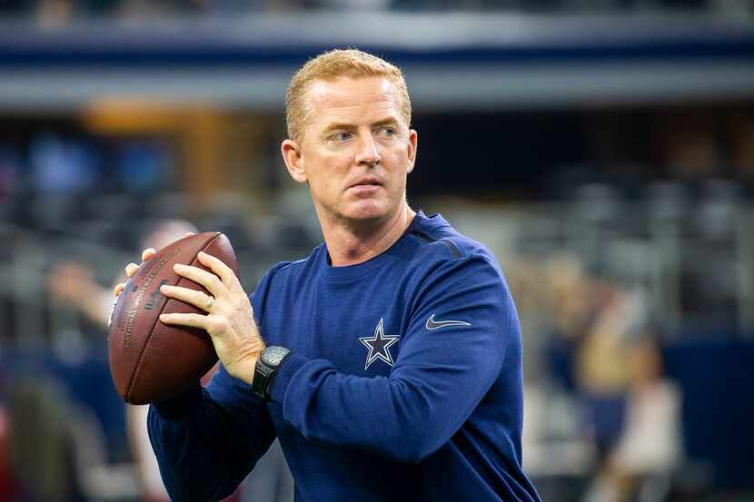 Dallas Cowboys head coach Jason Garrett throws passes before an NFL football game against...