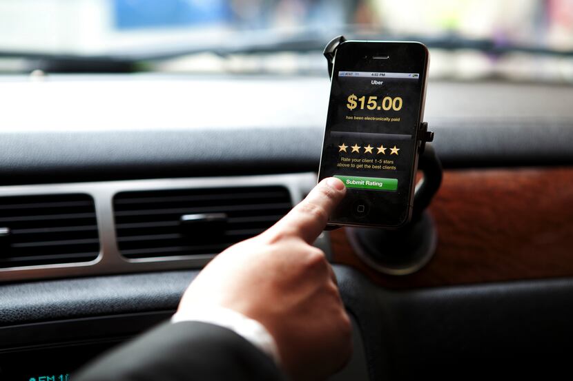 FILE — A driver uses the Uber app, near the car service app’s headquarters in New York, May...
