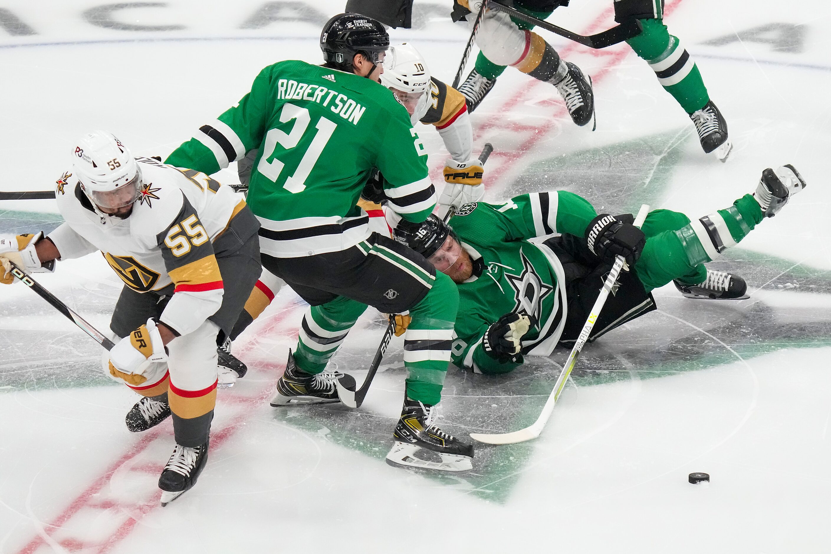 Dallas Stars center Joe Pavelski (16) slips to the ice as left wing Jason Robertson (21) and...