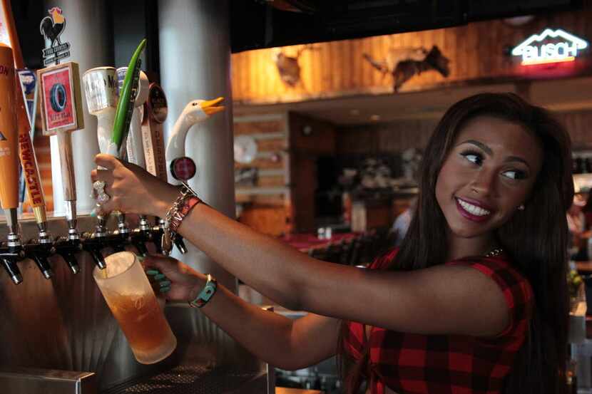 Twin Peaks bartender D'Moirae Scott pours a draft beer for a customer during a weekday lunch...