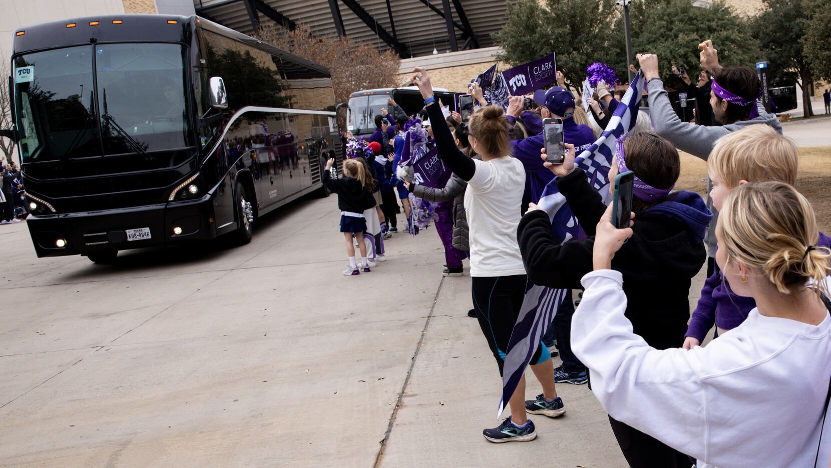 TCU Horned Frogs fans cheer as football players, coaches and support staff leave on charter...