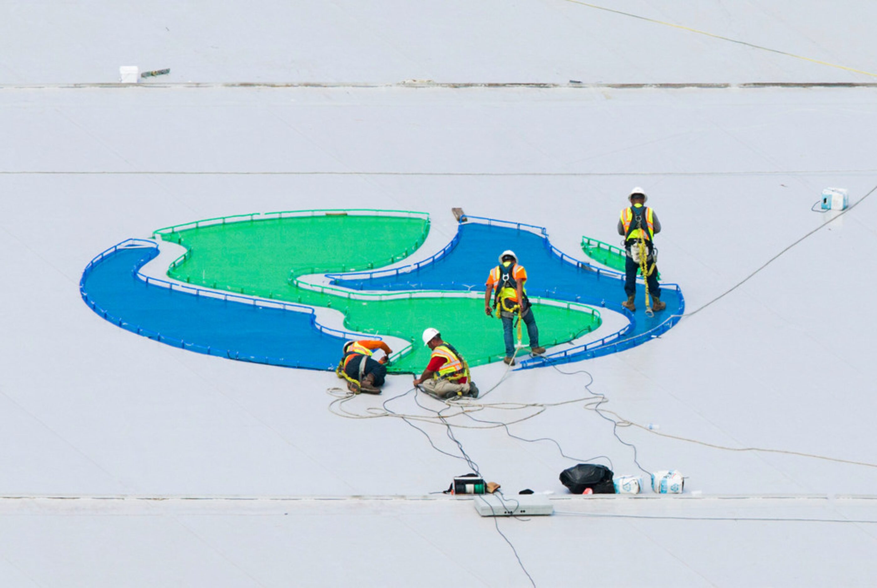 Crews work on a Globe Life Field logo on the roof of the stadium during an open house for...