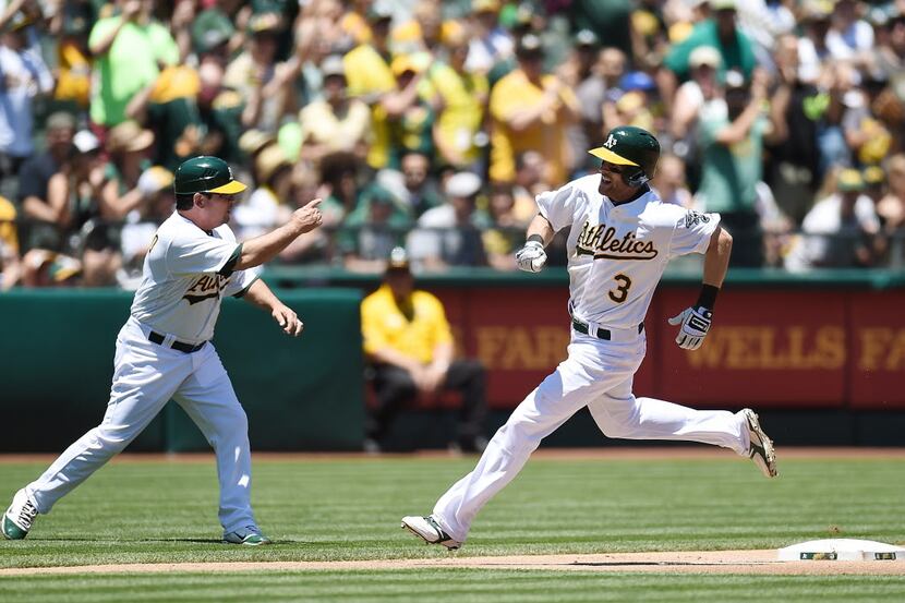 Craig Gentry #3 of the Oakland Athletics races around third to score on an RBI double from...