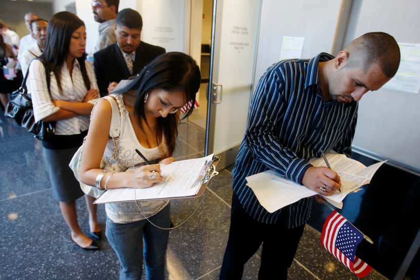 New U.S. citizens fill out voter registration forms. (File Photo/The Associated Press)