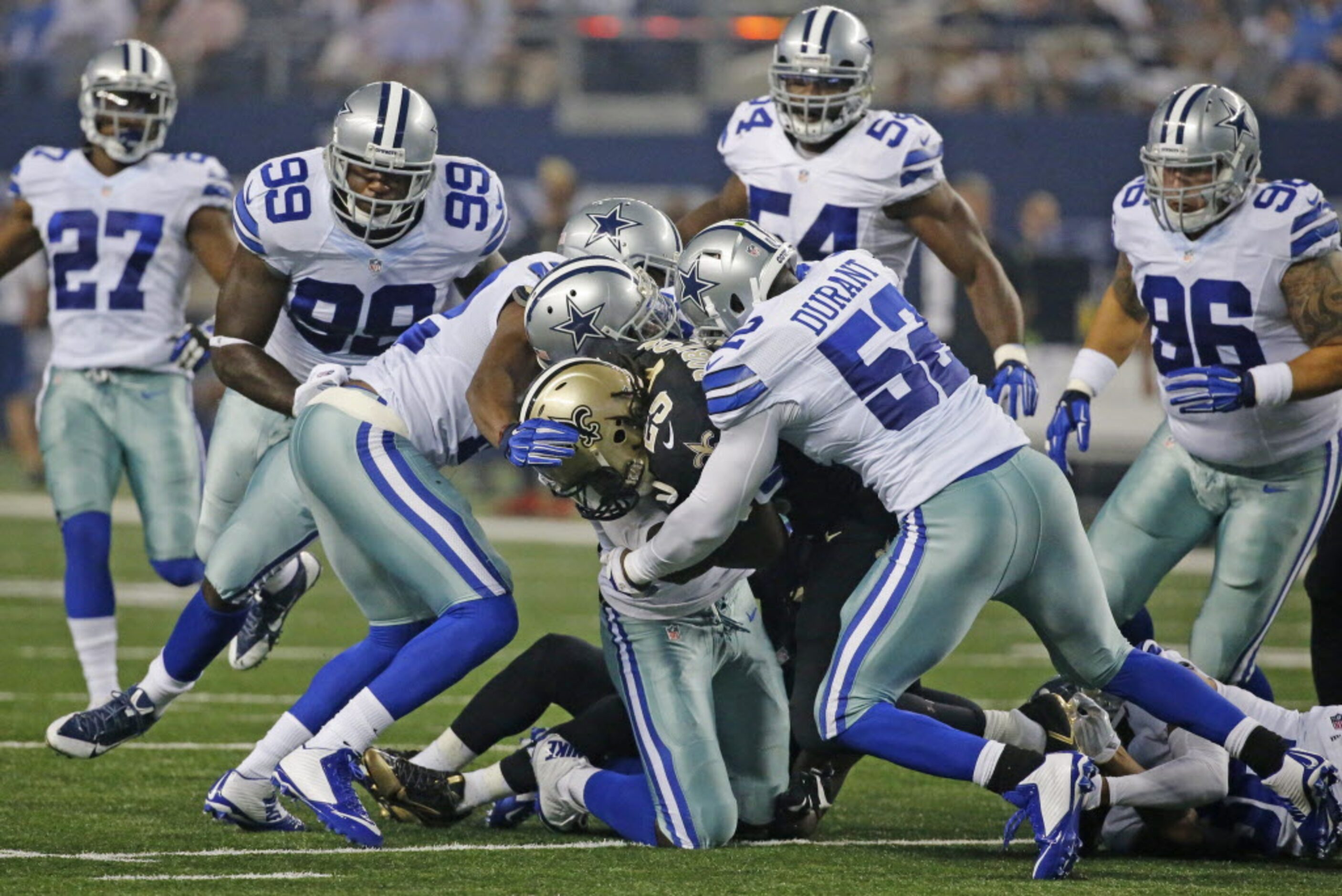 A host of Dallas defenders stop New Orleans Saints running back Khiry Robinson (29) on a...