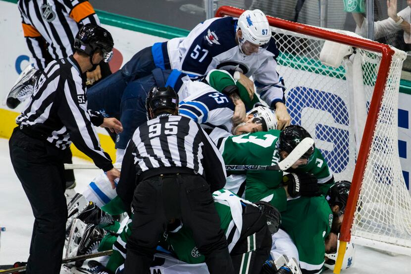 The Dallas Stars and Winnipeg Jets end up in the goal during a fight in the third period of...