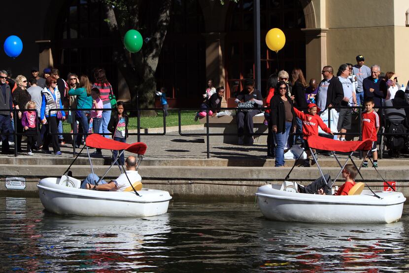 A man and young boy use rented boats to tour the revived Canal Fet in 2013 at Las Colinas...