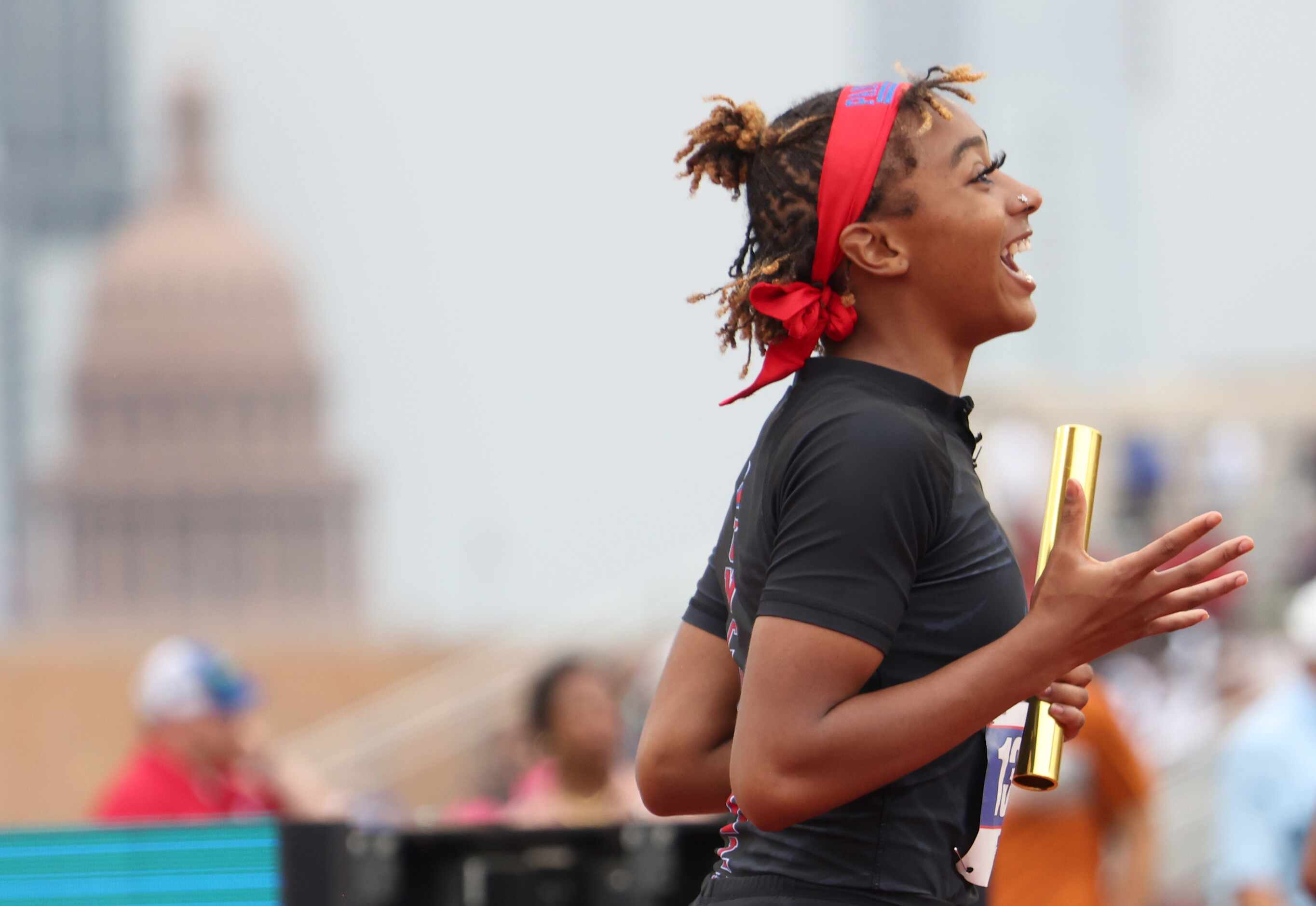 Duncanville's Sanyah Keeton reacts at the finish line with the state capitol in the...