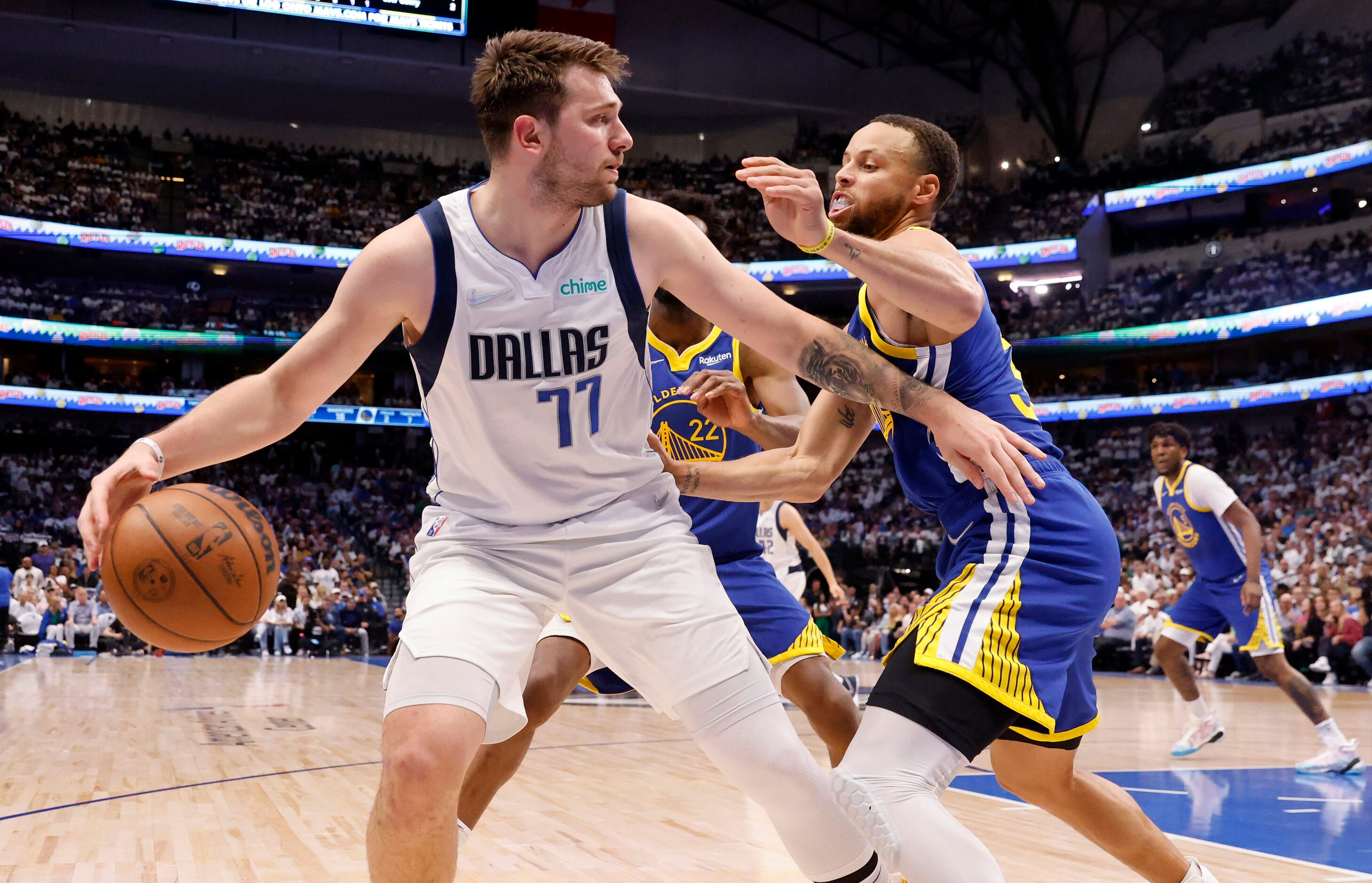 Dallas Mavericks guard Luka Doncic (77) keeps the ball away from Golden State Warriors guard...