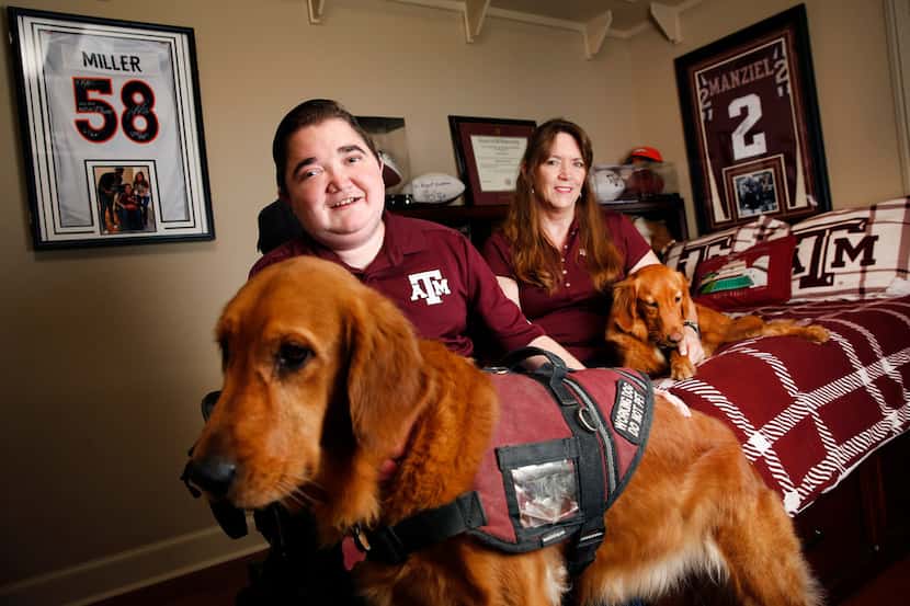 Texas A&M graduate student Kyle Cox (left), who has Duchenne muscular dystrophy, poses with...