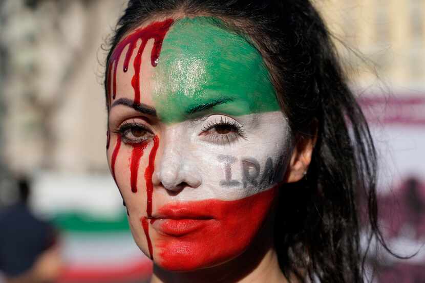 A woman is painted on a her face during a protest against the death of Mahsa Amini, a woman...