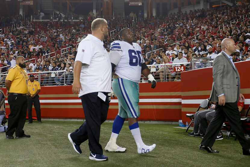 Dallas Cowboys offensive guard Marcus Martin (60) walks off the field to check his injury...