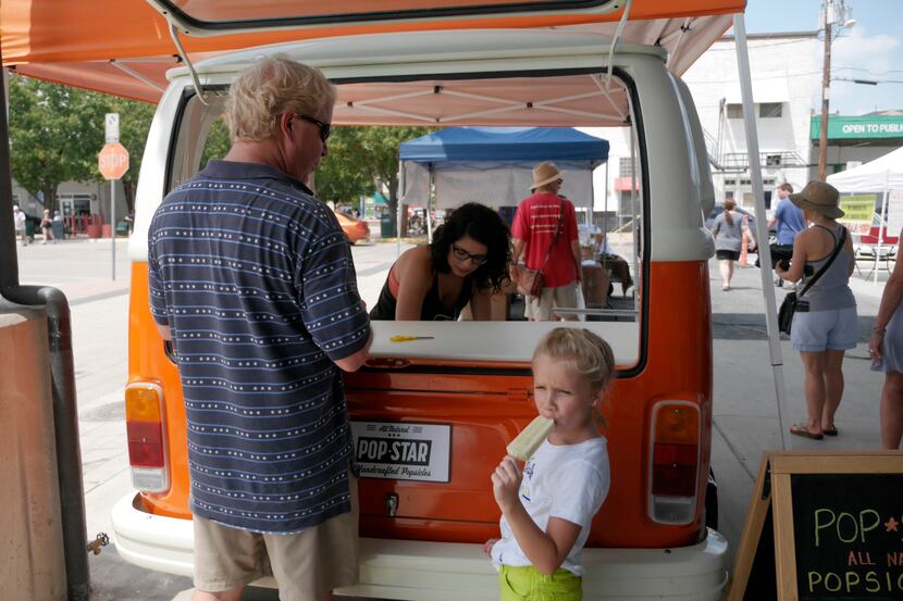Jason Runnels buys his daughter, Ellie Rose, an all-natural popsicle from Alicia Avila at...