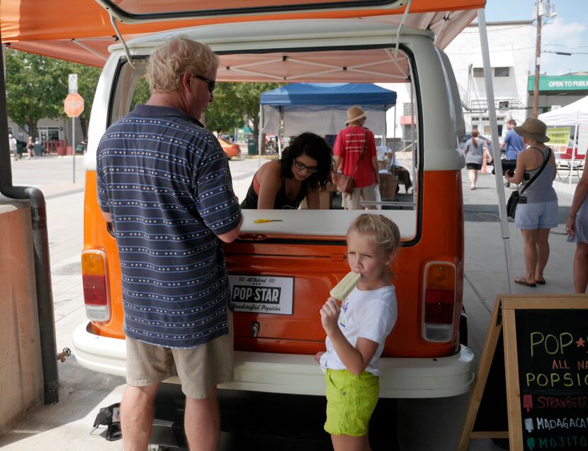 Jason Runnels buys his daughter, Ellie Rose, an all-natural popsicle from Alicia Avila at...