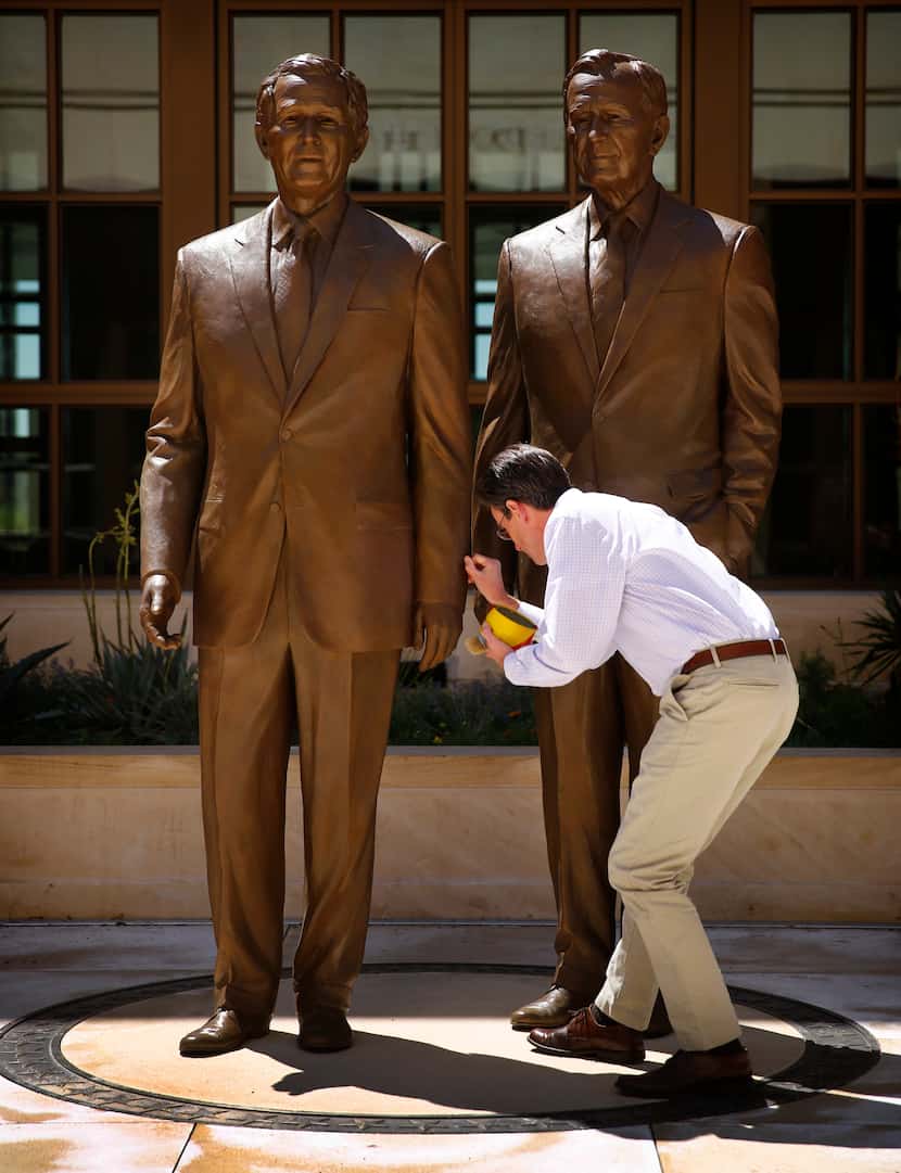 2013: Sculptor Chas Fagan of Charlotte applies wax to the 8-foot bronze statues he created...