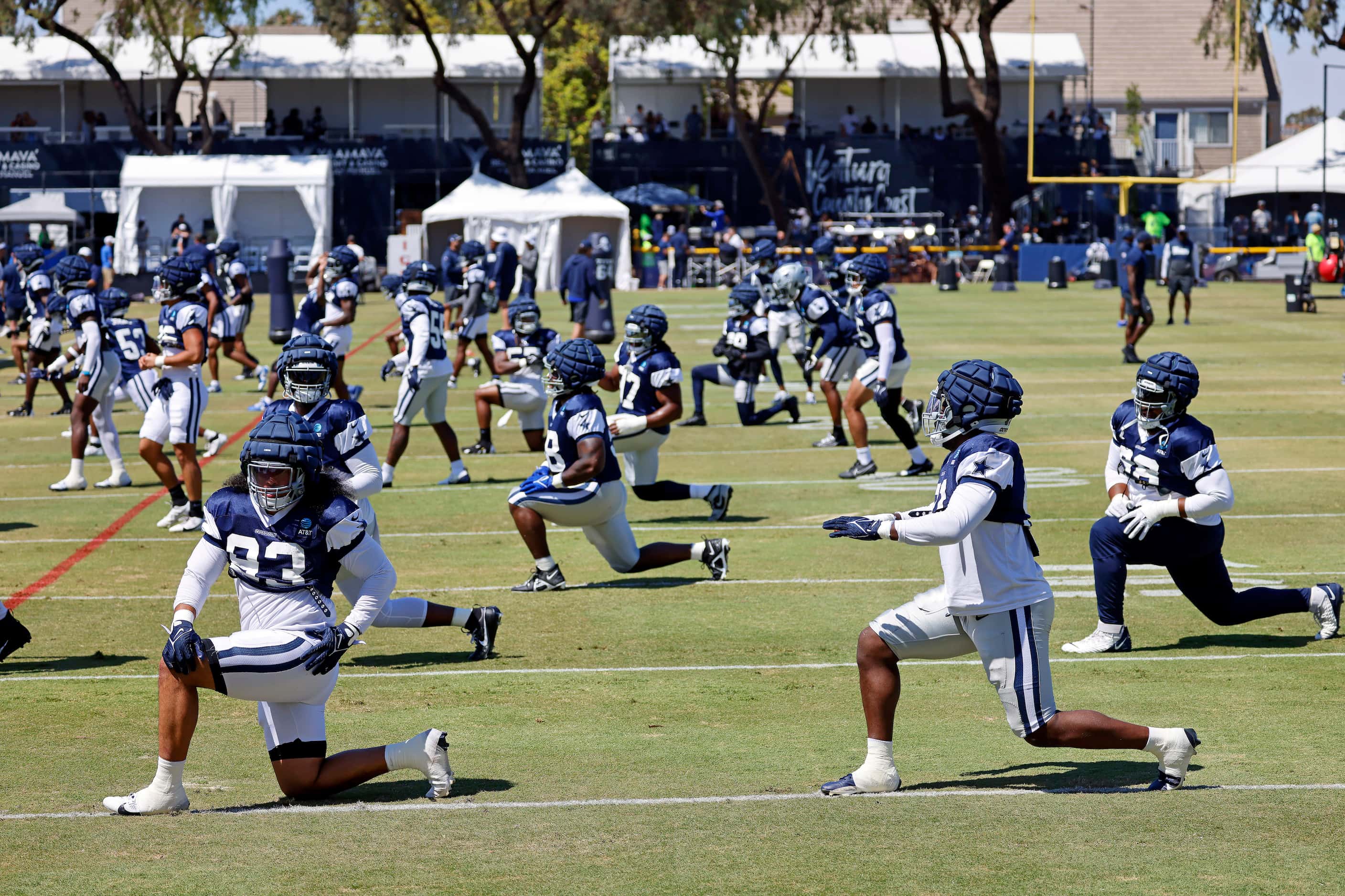 The Dallas Cowboys defense stretches before training camp practice begins in Oxnard,...