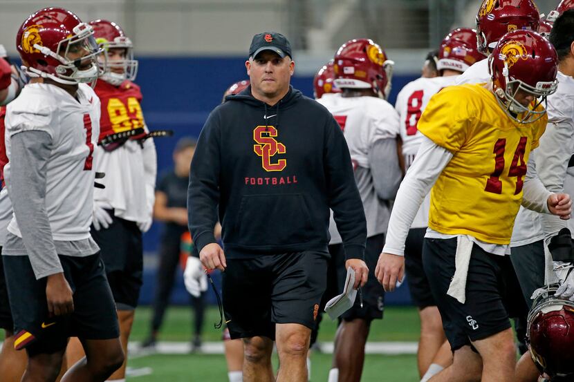 USC head coach Clay Helton walks on the field during practice at AT&T Stadium in Arlington,...