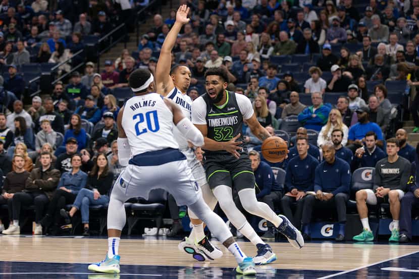 Minnesota Timberwolves center Karl-Anthony Towns (32) moves towards the basket while being...