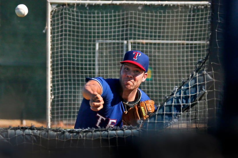 Texas pitcher Colby Lewis throws a batting practice pitch during Texas Rangers baseball...