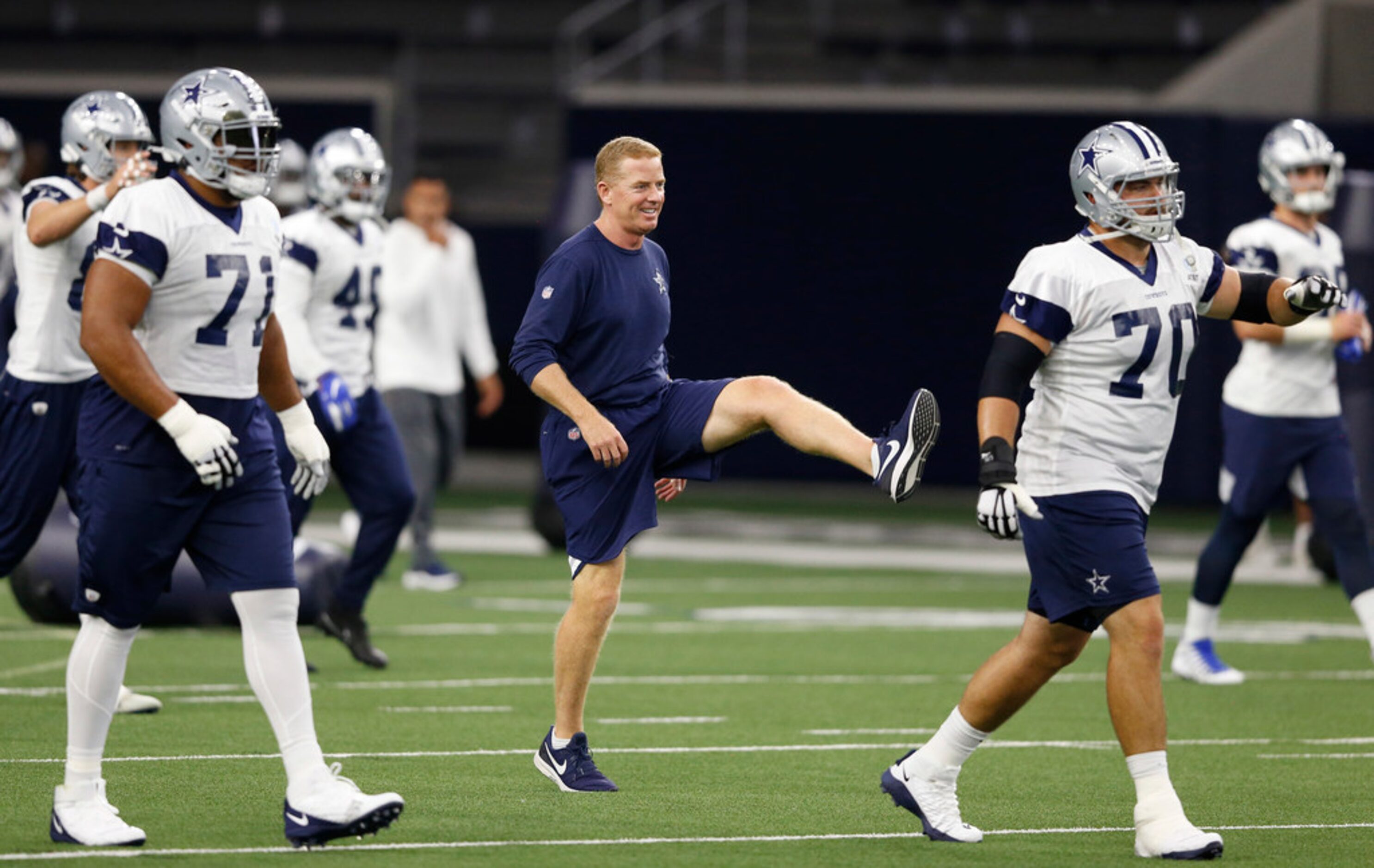 Dallas Cowboys head coach Jason Garrett stretches with Dallas Cowboys offensive tackle La'el...