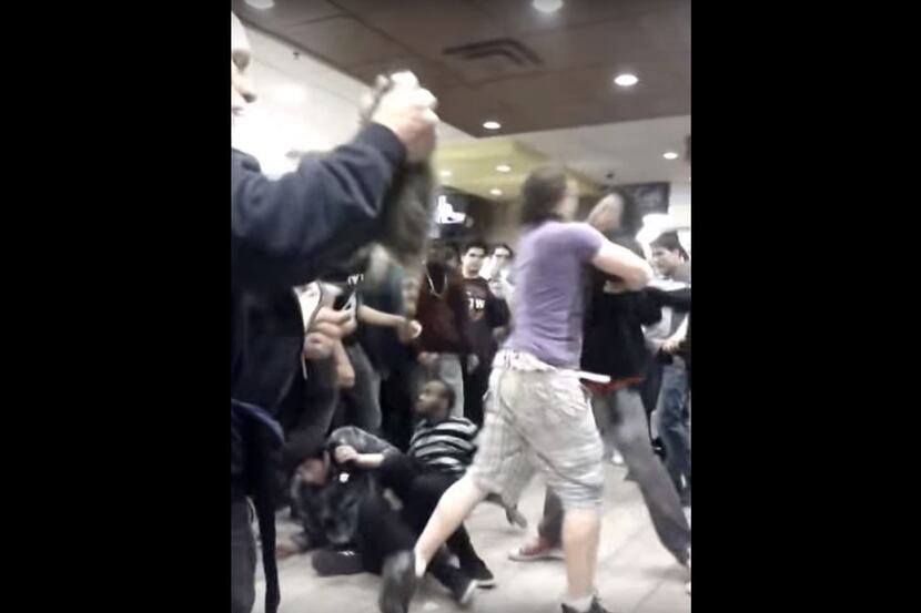 A screen shot of a McDonald's fight video that shows a raccoon amid the melee.