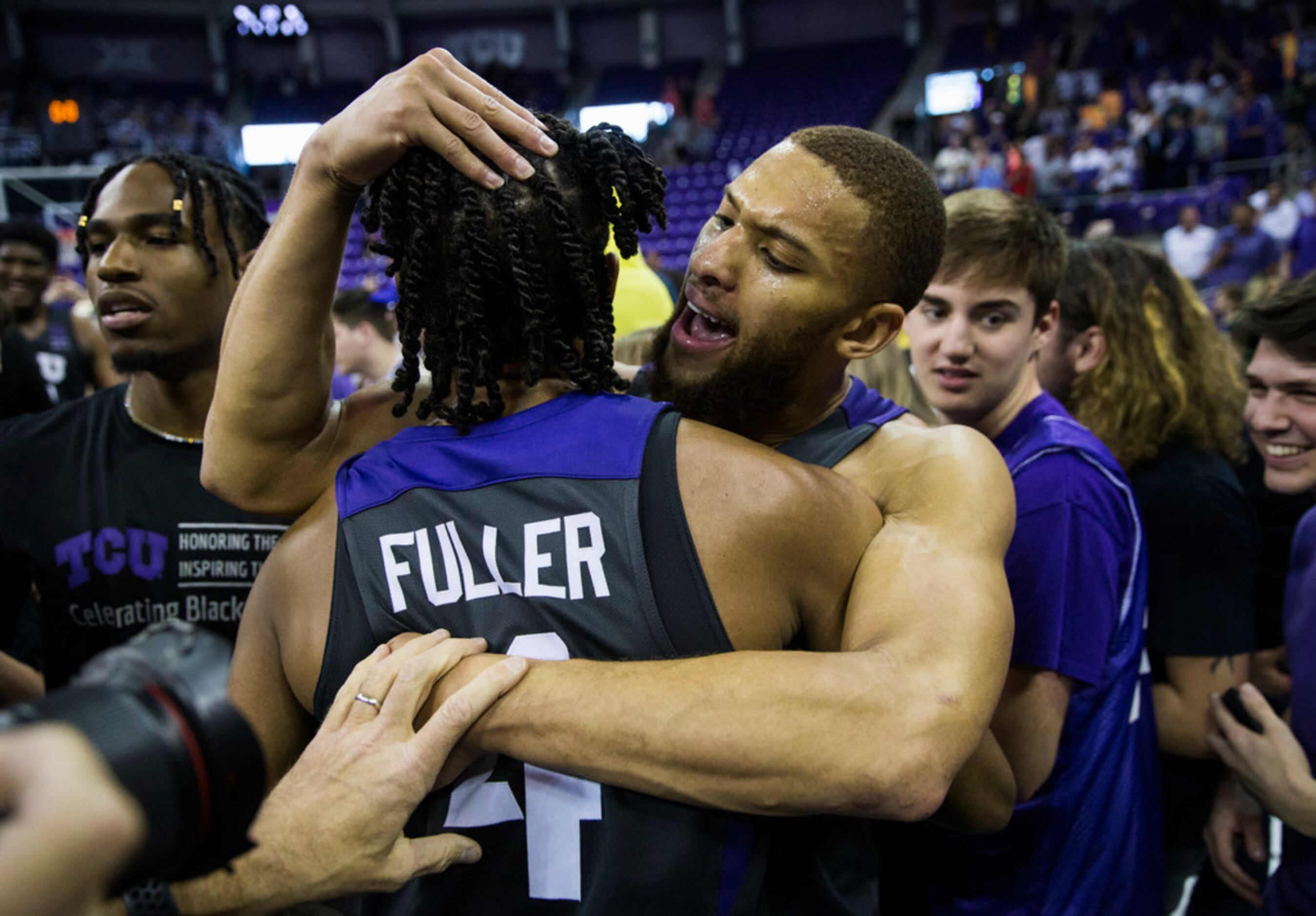 TCU Horned Frogs guard Edric Dennis (2) and guard PJ Fuller (4) celebrate after fans rush...