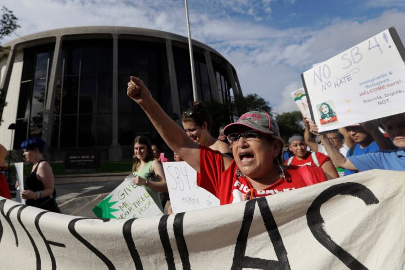 Protesters march outside the Federal Courthouse to oppose a new Texas "sanctuary cities"...