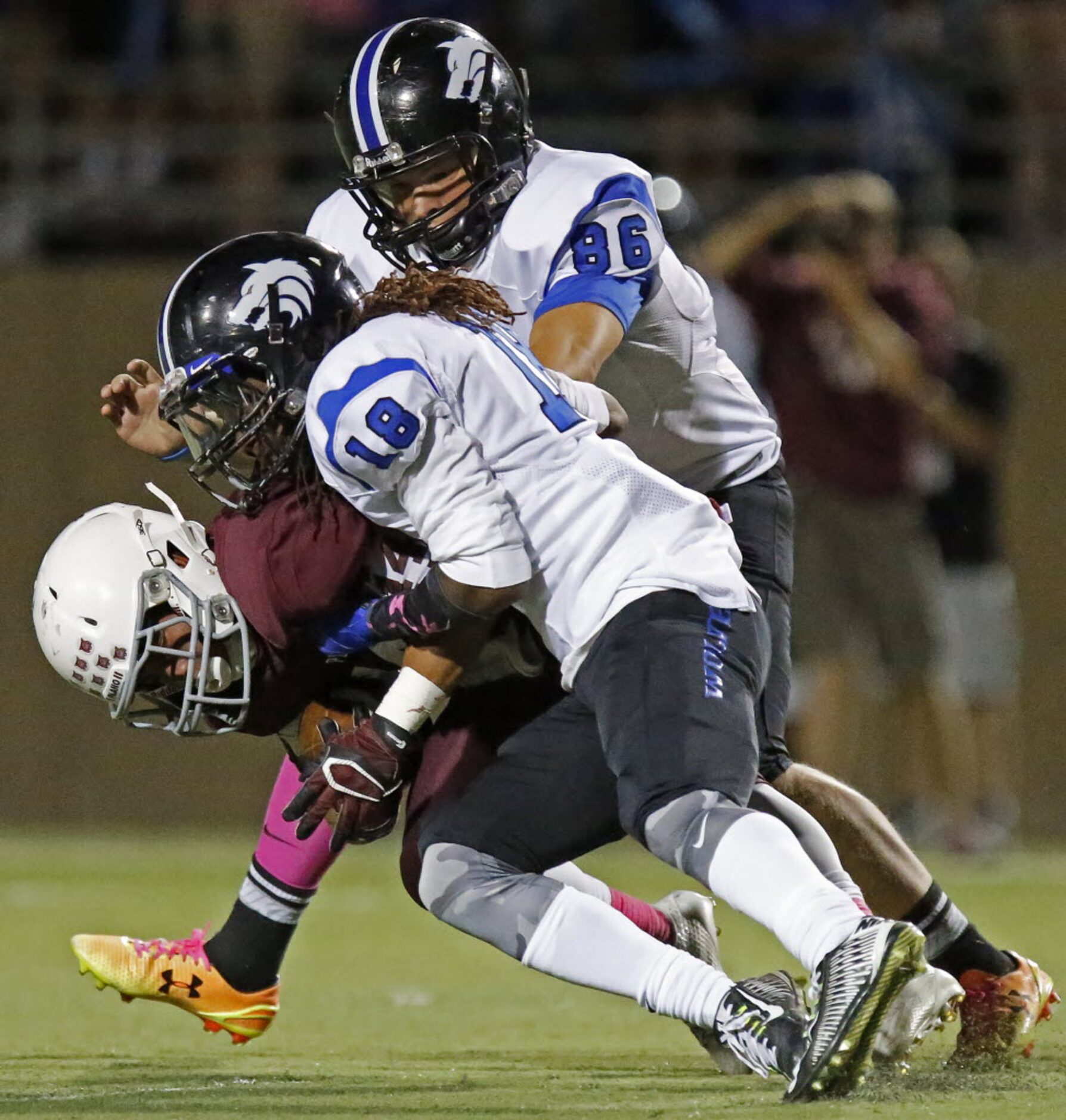 Plano kick returner Lopaka Yoro (14) is ridden to the ground by Plano West defensive back...