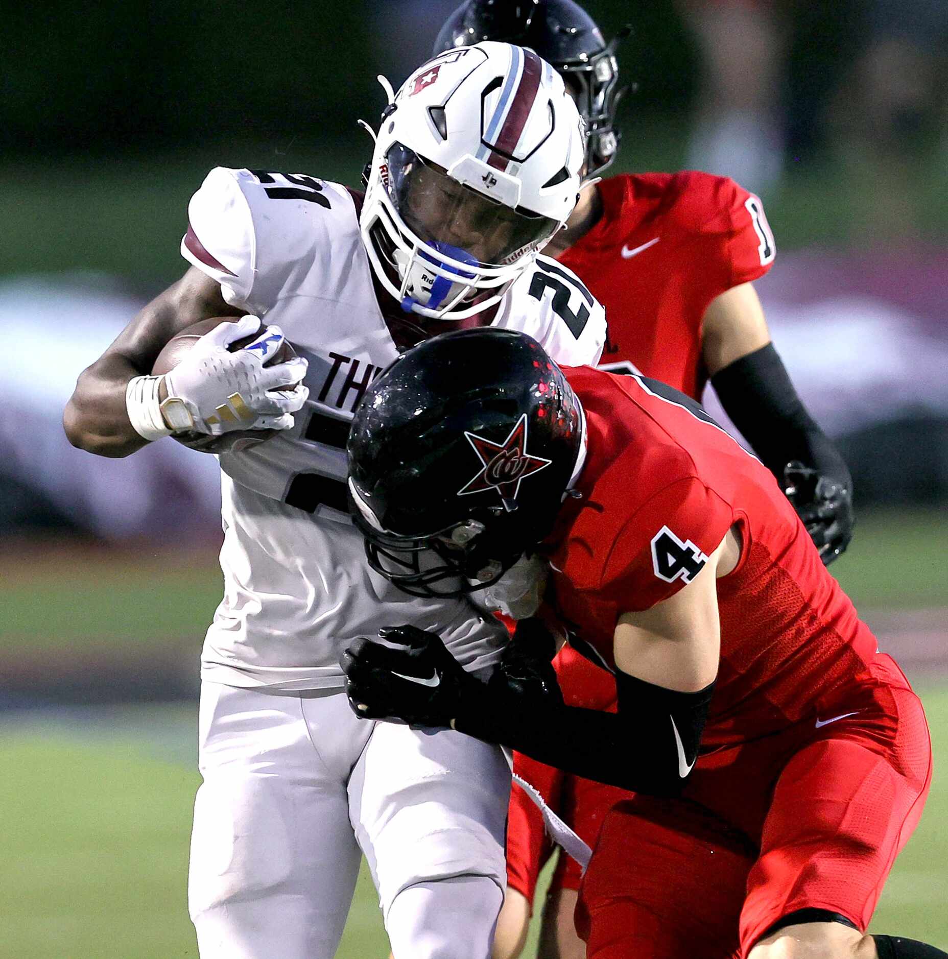 Lewisville running back Viron Ellison (21) takes a shot from Coppell safety Scott Fishpaw...