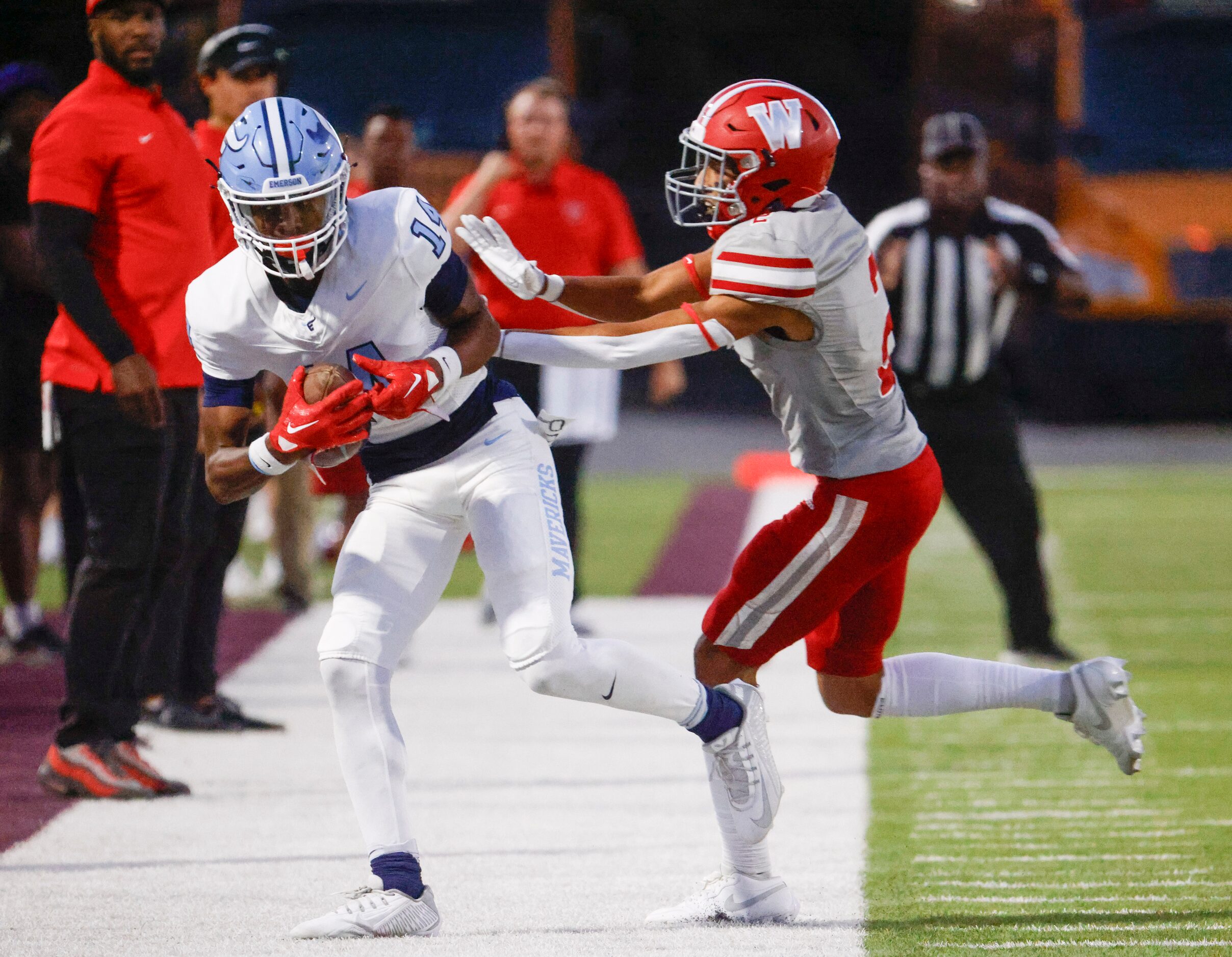 Emerson high’s Kelton Wafer (left) gets tackled by Woodrow Wilson’s Jamion Nash (2) during...