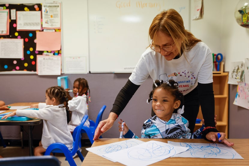 Teacher Carmen Negron helps out Janelle Butler with her painting at Kaleidoscope Child...