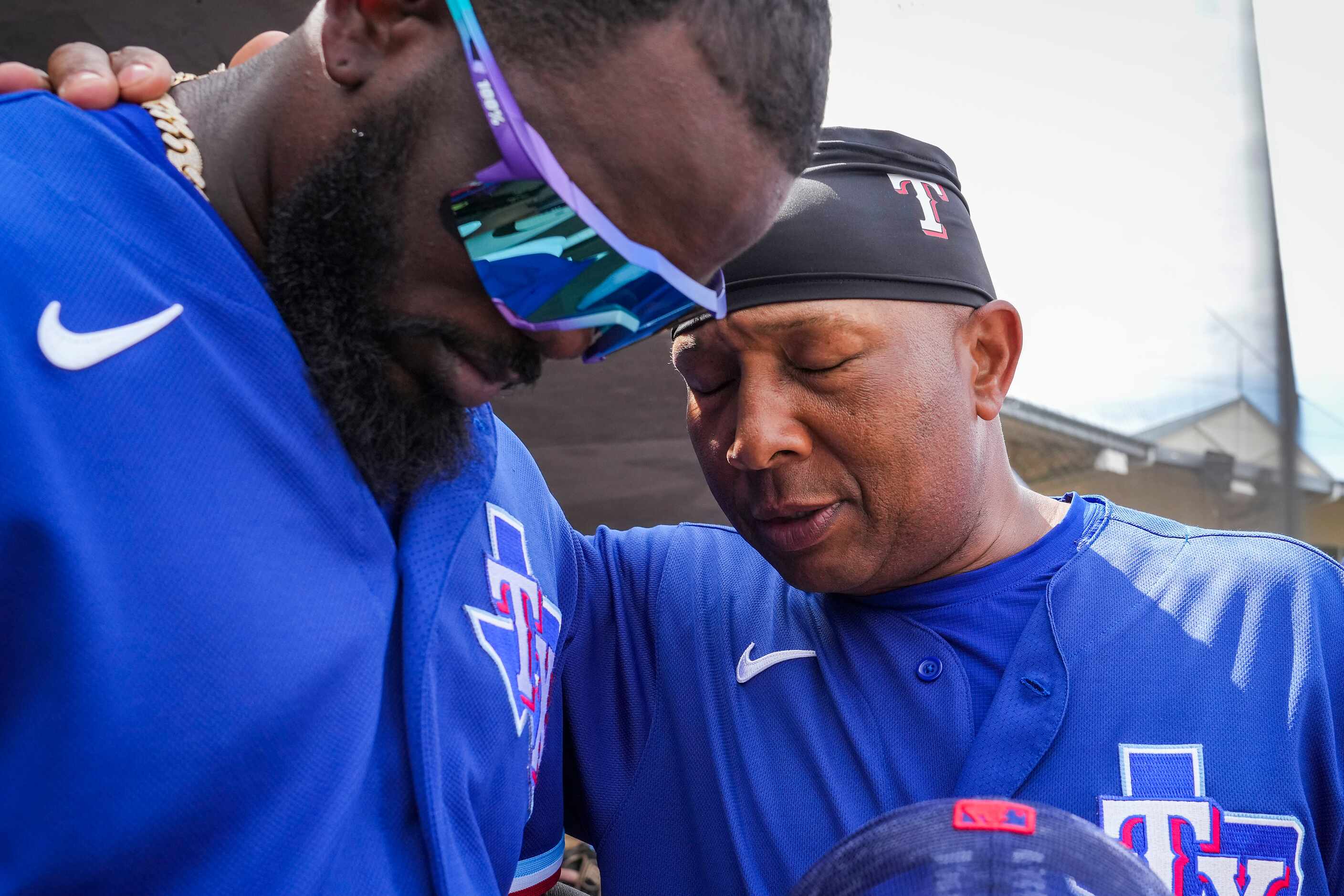 Texas Rangers outfielder Adolis García (left) prays with third base coach Tony Beasley in...