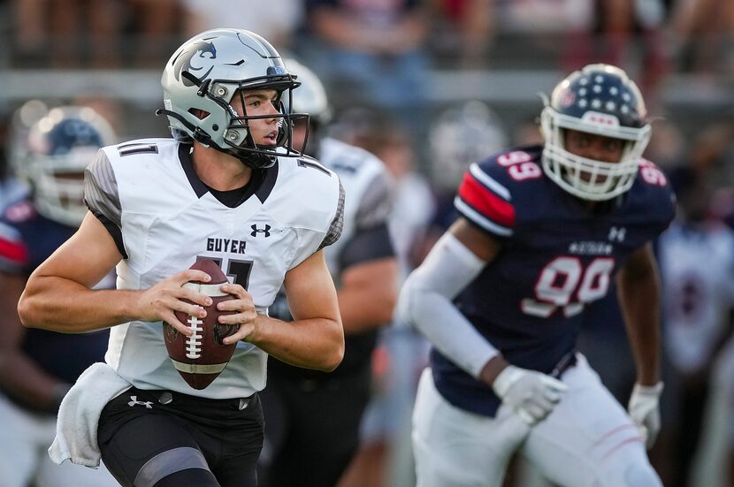 Denton Guyer quarterback Jackson Arnold  (11) scrambles away from Denton Ryan defensive...