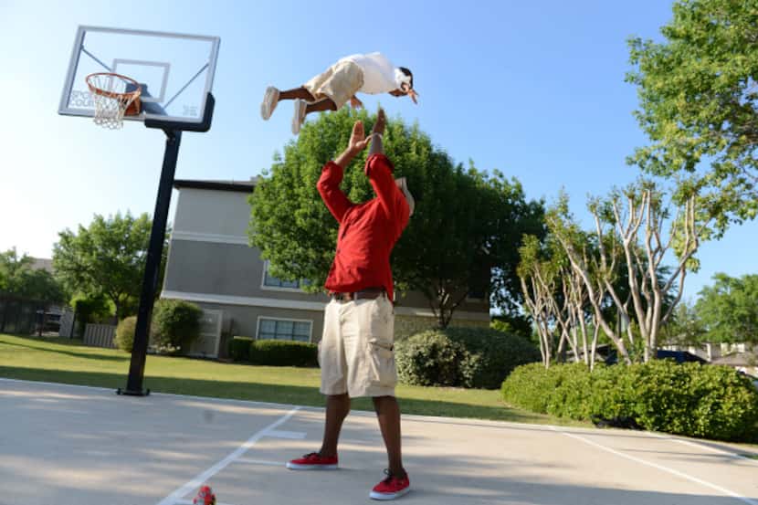 Charles Davis plays with his son Chas, 3, on the basketball court near their apartment...