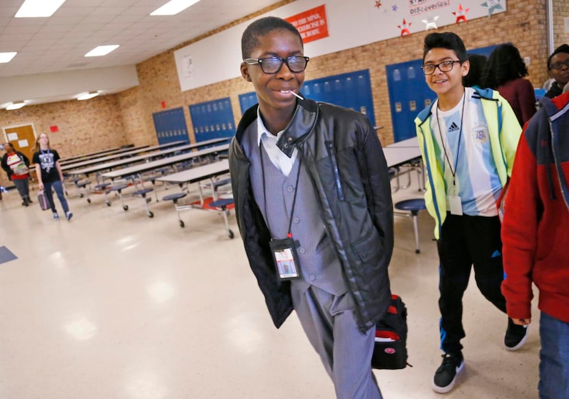 
Lee Kamara (center) chats with friends, including Emmanuel Rayo, just after his band class...