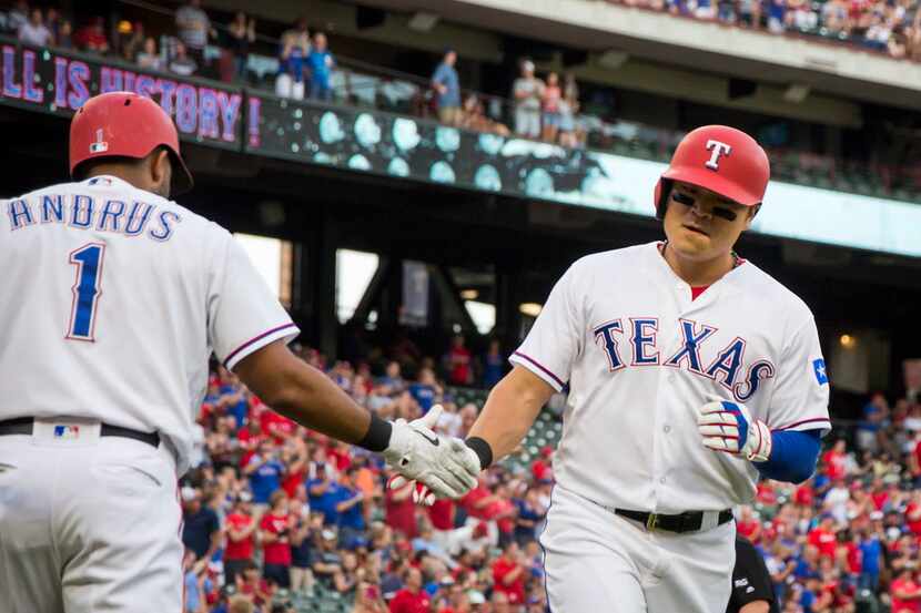 Texas Rangers designated hitter Shin-Soo Choo celebrates with shortstop Elvis Andrus after...