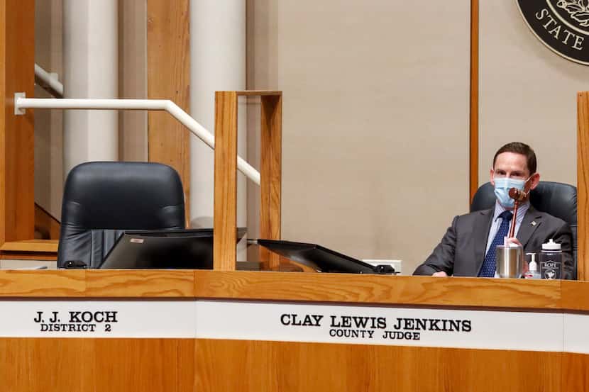 Dallas County Judge Clay Jenkins bangs a gavel next to the empty seat of Dallas County...