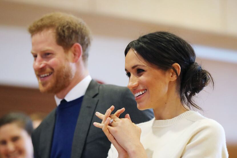 Britain's Prince Harry (left) and fiancee Meghan Markle speak with staff during a visit to...