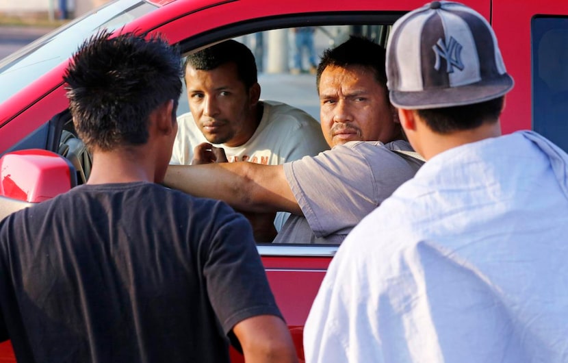 
Contractors talked to day laborers in Oak Cliff on a recent morning about a roofing job. 
