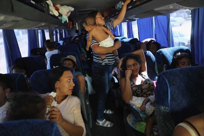 Central American asylum-seekers ride a bus to Tijuana on April 25, 2018 while passing...