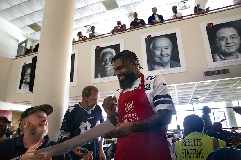 Dallas Cowboys running back Ezekiel Elliott (center) signs autographs after Elliott and...