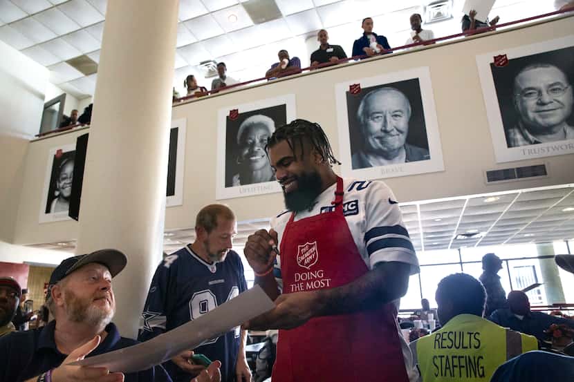 Dallas Cowboys running back Ezekiel Elliott (center) signs autographs after Elliott and...