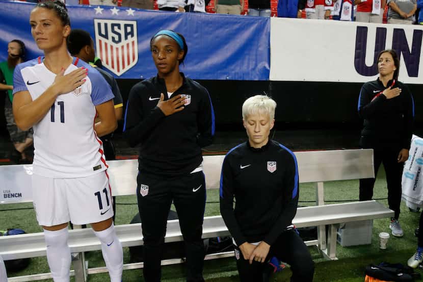 U.S. soccer player Megan Rapinoe took a knee next to teammates Ali Krieger (left) and...