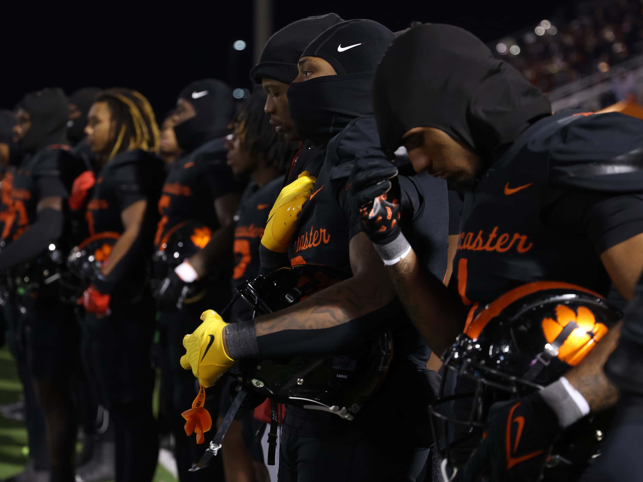 Lancaster players pause for the playing of the national anthem before the opening kickoff of...