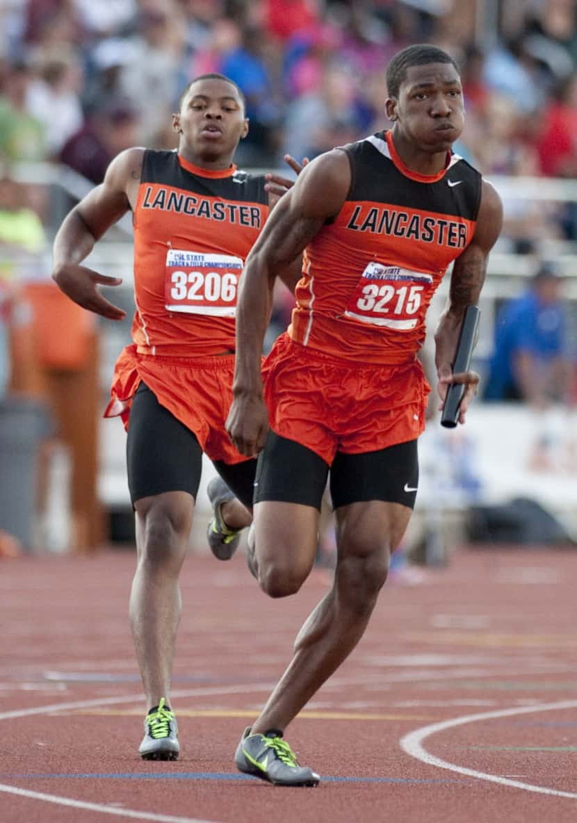 Lancaster's Xavier Caffee, left, hands off the baton to Gabriel Walker, right, during boys...