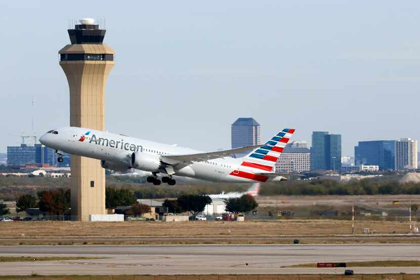 An American Airlines jet takes off past the control tower at DFW Airport, Nov. 27, 2023.