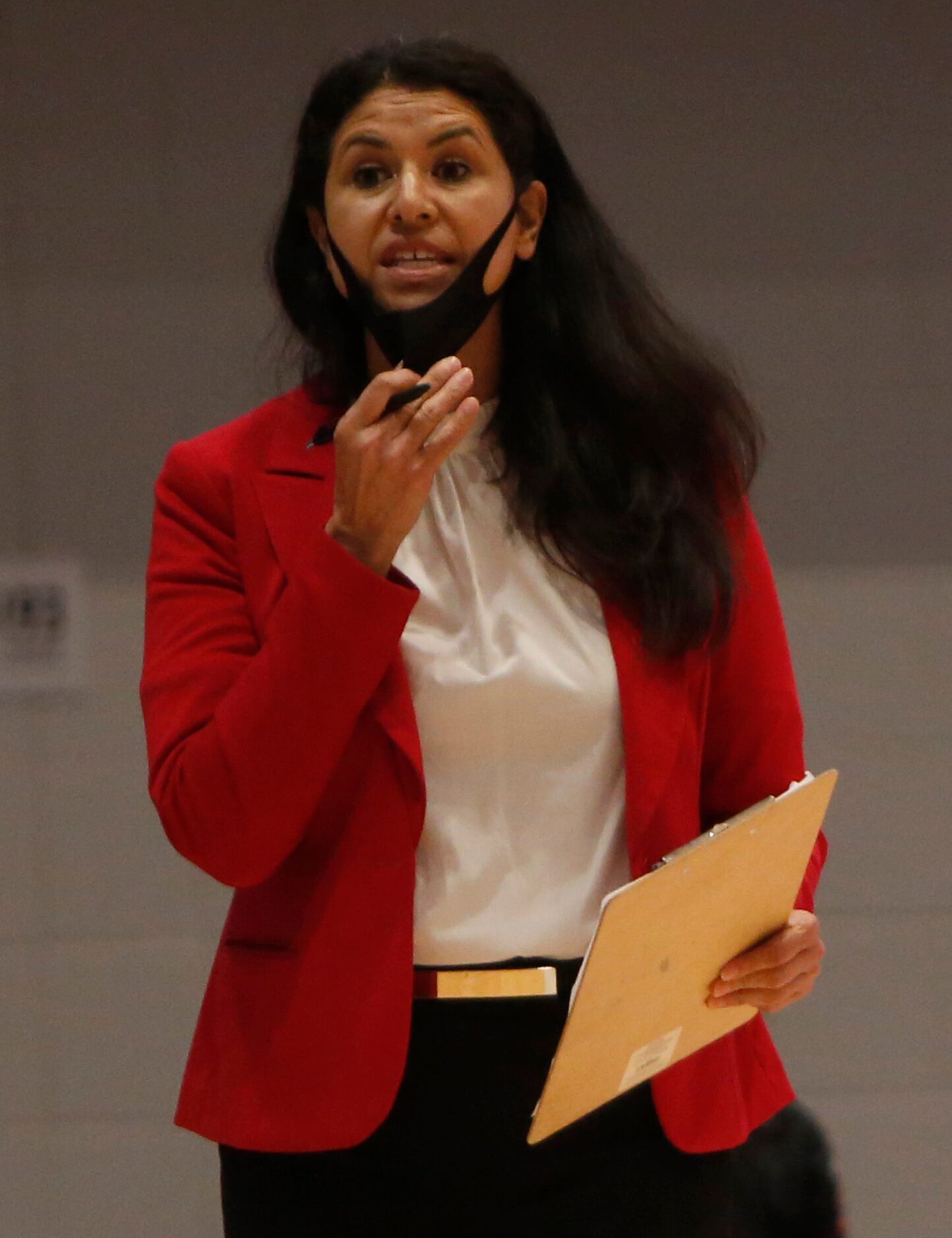 Arlington Martin head coach Tracy Perez-Petersen lowers her face mask to deliver directions...