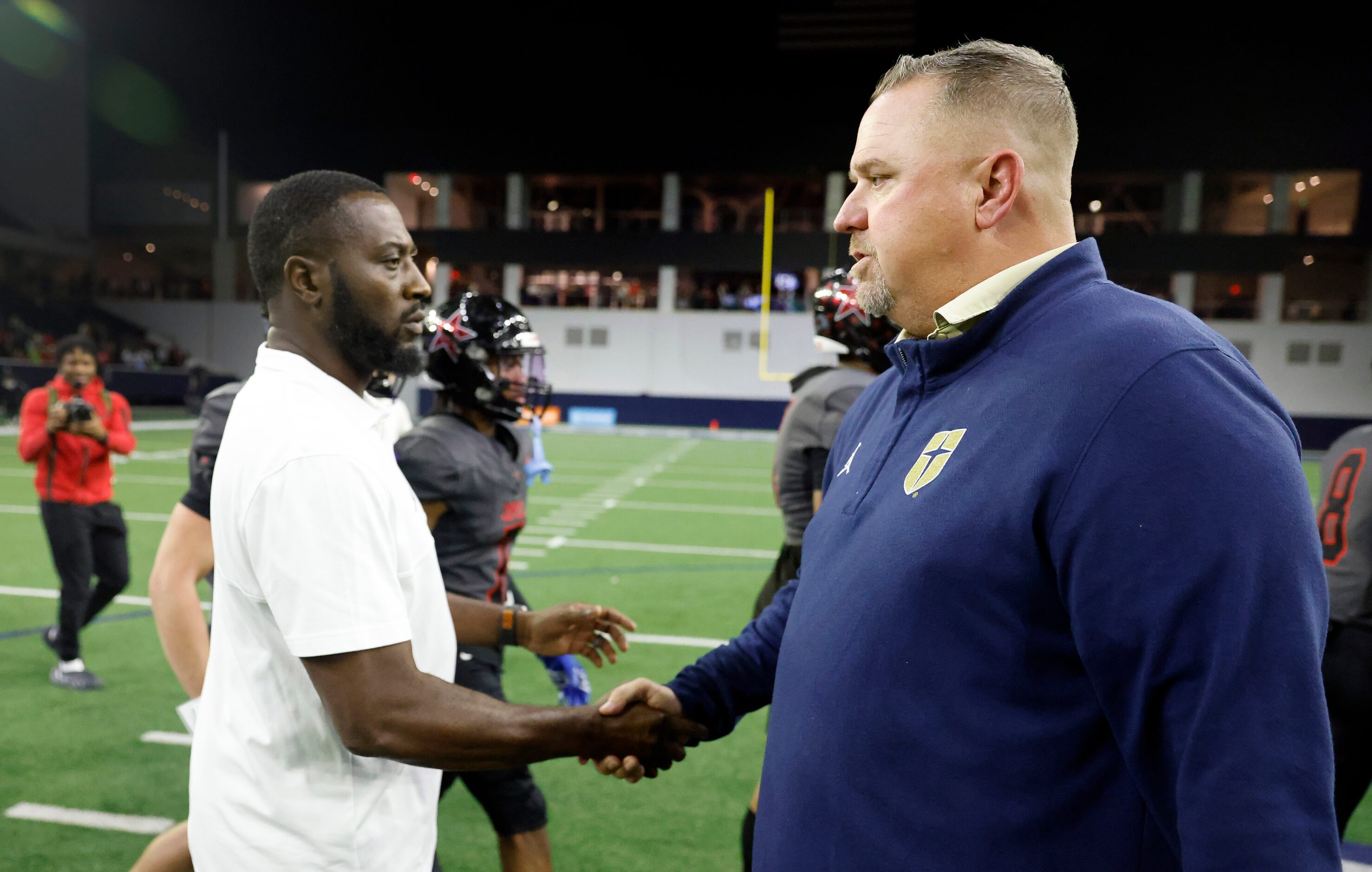 Coppell head coach Antonio Wiley (left) and Jesuit head coach Brandon Hickman shake hands...